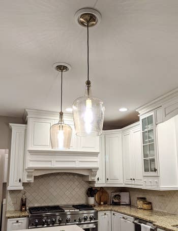 reviewer showing their two pendant lights over he kitchen island after using the conversion kit